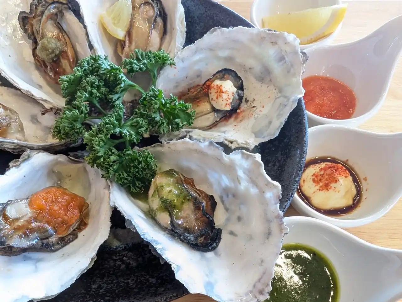 【ウッドデザインパーク株式会社】 「次はどの味にする？」知多半島・海沿い牡蠣小屋で平日だけの“味変し放題”の牡蠣食べ放題！【牡蠣小屋ウッドデザインパーク野間】