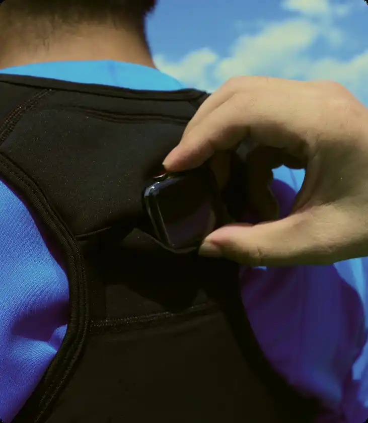 専用スポーツベストの背中にアップルウォッチを入れるシーン