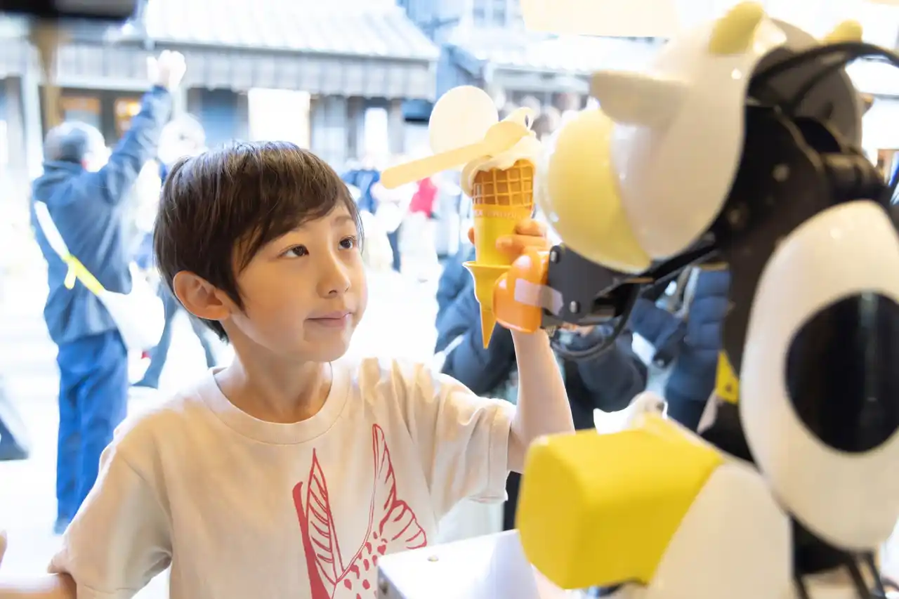 販売数2倍・人件費11％削減のソフトクリームロボ「モーモー」、修学旅行の高校生考案の“おみくじ機能”を12月8日搭載へ