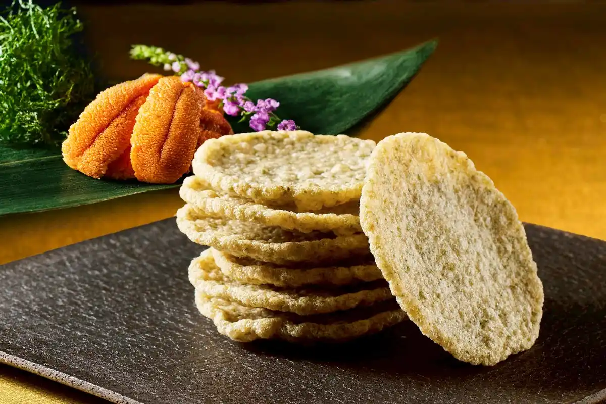 【株式会社シュクレイ】 “さっくさく”に揚げた天ぷらせんべいに雲丹と青のりを合わせた自慢の逸品。築地ちとせより「雲丹のり天せんべい」が期間限定で発売。