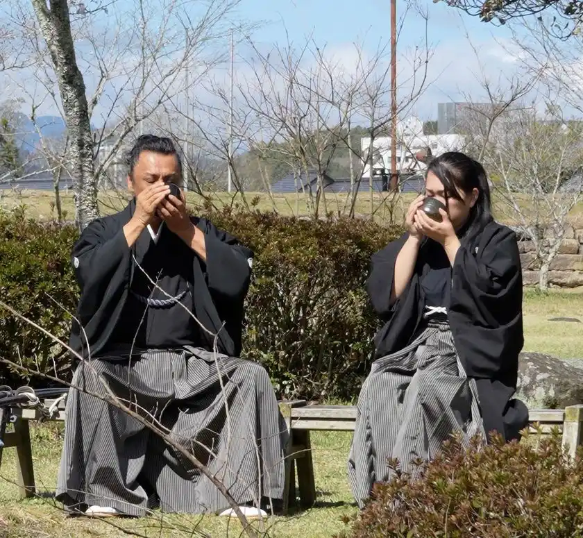 →三日月ノ城(人吉城・国史跡)に鎮座する相良神社で抹茶を召し上がる 兵法タイ捨流 第15代目宗家・上原エリ子さま(写真：右)、兵法タイ捨流 龍泉館館長・山本隆博さま