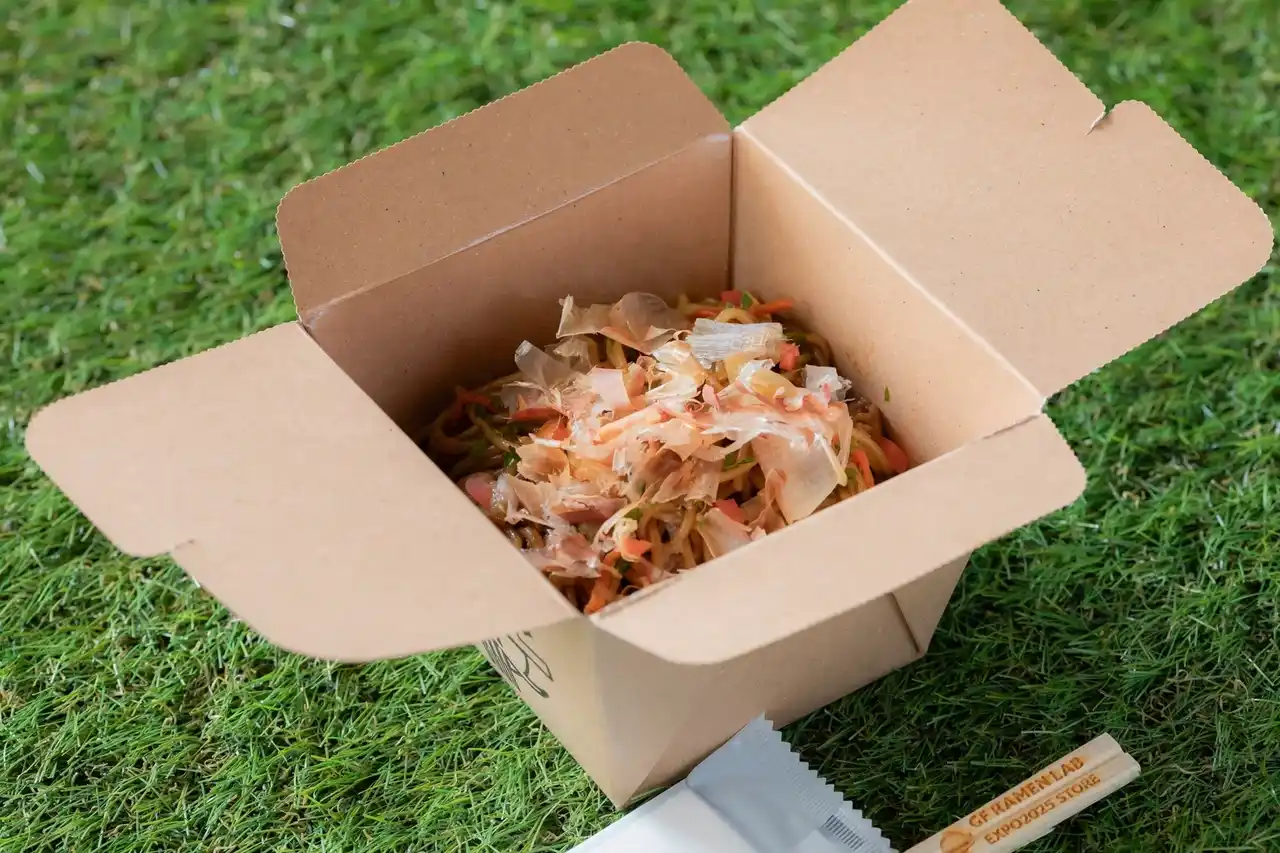 【ケンミン食品株式会社】 話題の「GF RAMEN LAB 大阪・関西万博店」で新たなテイクアウトメニューが登場！驚きのグルテンフリーメニューは、なんと焼そば!?